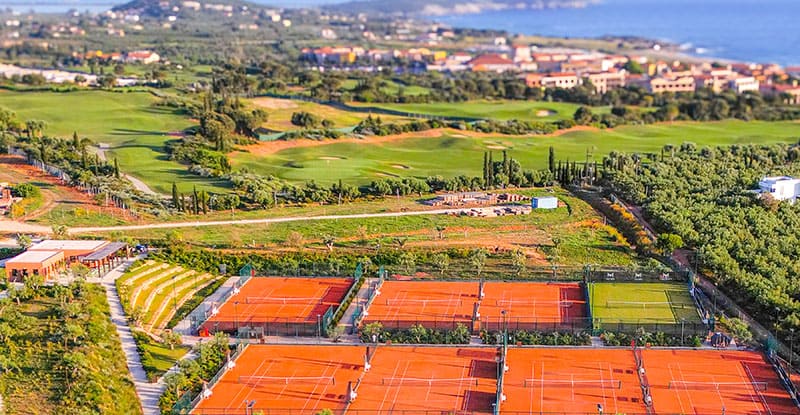 Aerial view of tennis courts by the coastline, overlooking the sea at Costa Navarino